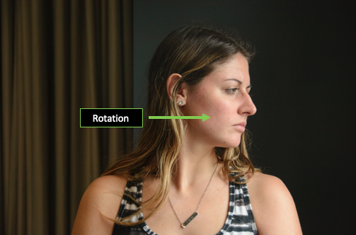 Person demonstrating cervical rotation with the direction of the motion designated by an arrow.