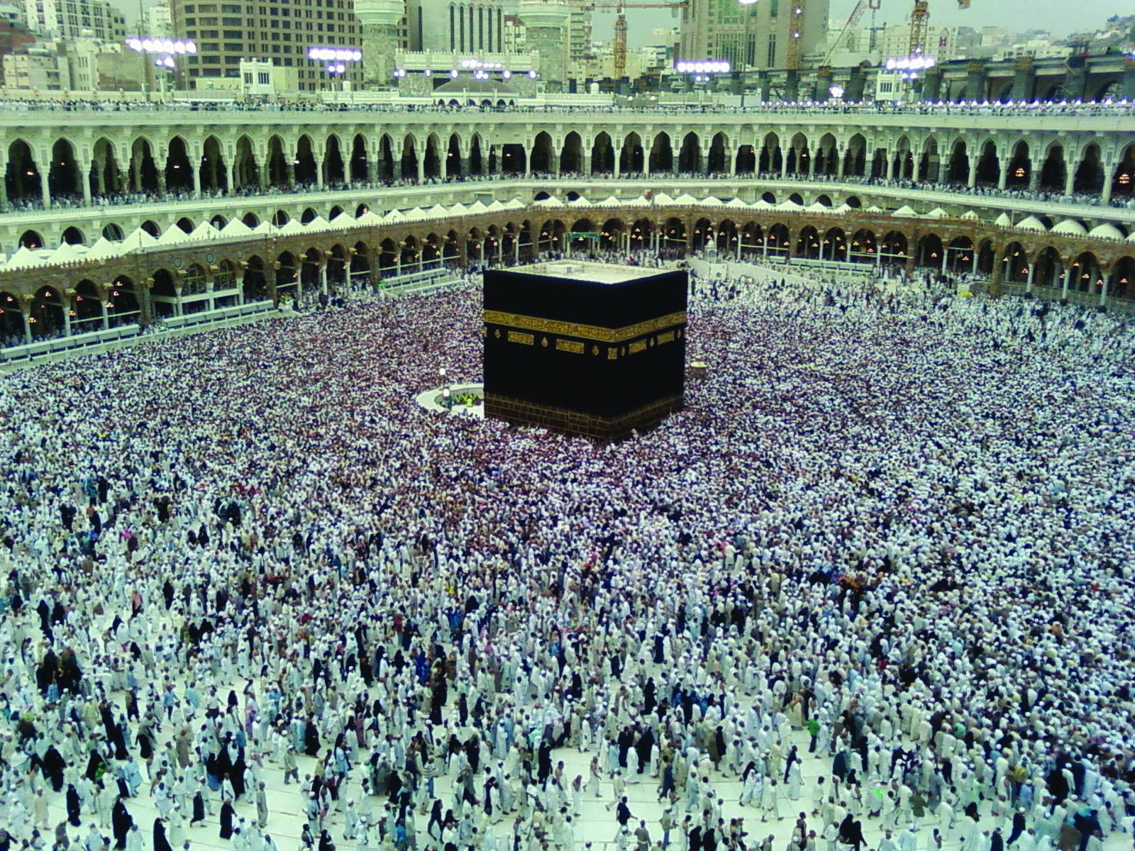 Color photograph of the Kaaba in Mecca during the pilgrimage, or haj, with countless Muslims circumventing the holiest place in their religion.