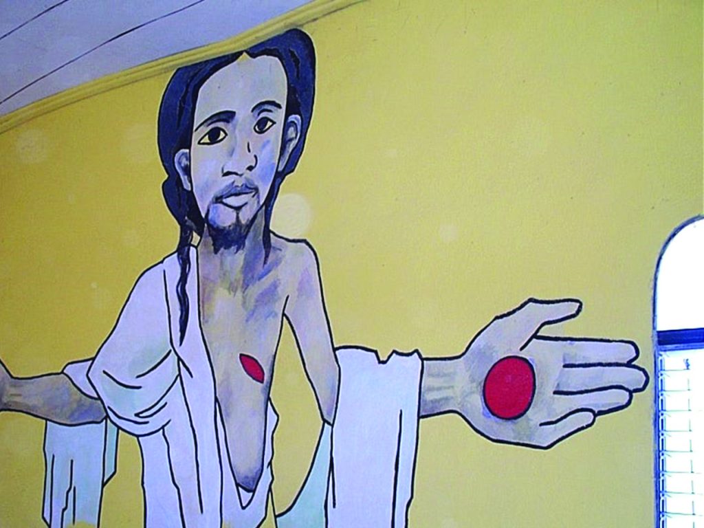 Color photograph of a mural of the resurrected Jesus ChristHe is black, wears dreadlocks, and displays the wounds from his crucifixion. Church of Saint Claire, Port-au-Prince, Haiti, ninety ninety-three.