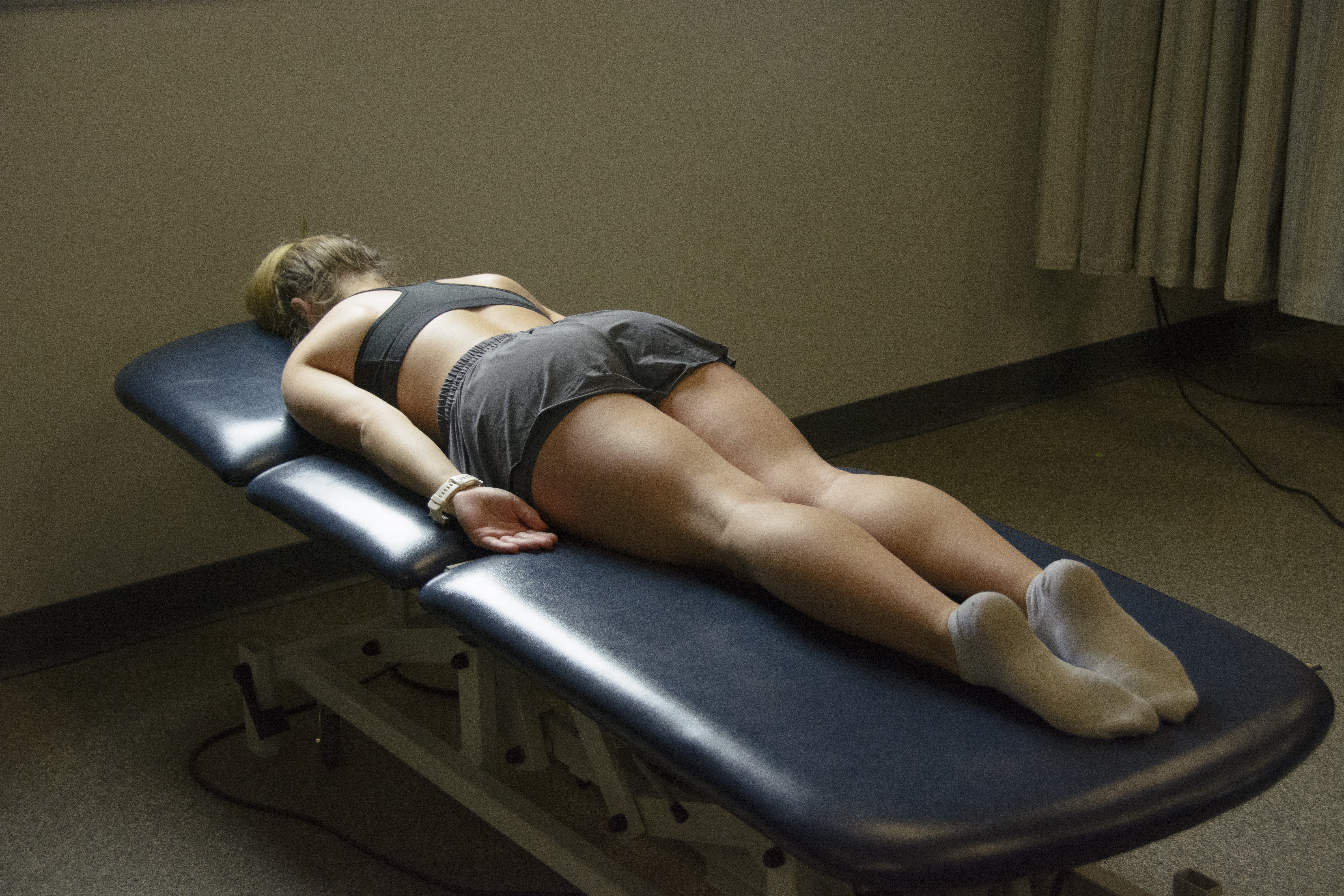Person laying in the prone position on an examining table.