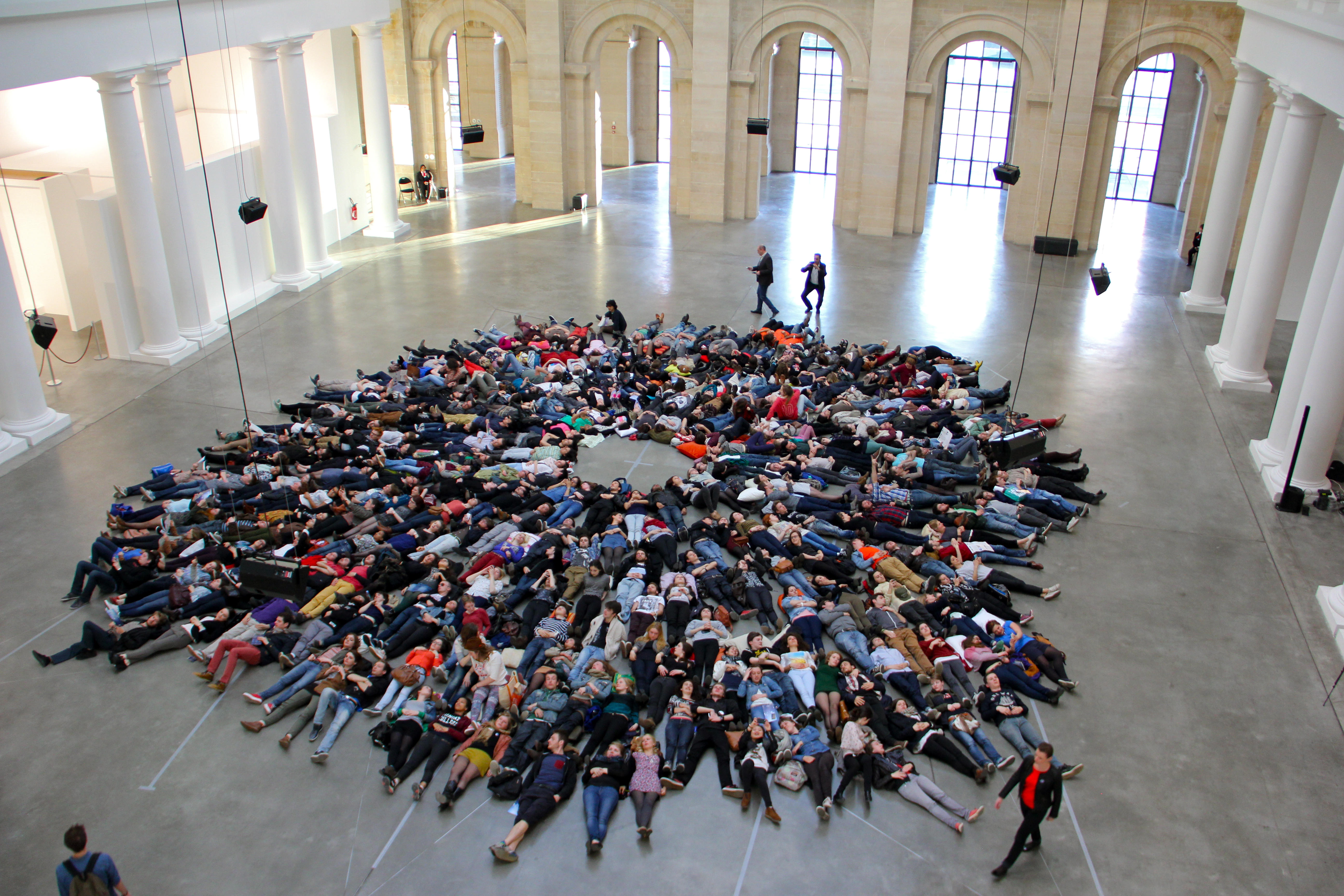 A flash mob in the form of a few hundred people lying on their backs in the main hall of the Palais des Beaux Arts in Lille, France.