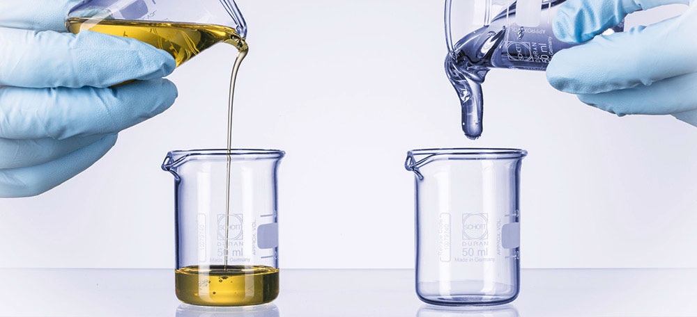 A person pouring liquid into a beaker

Description automatically generated with low confidence
