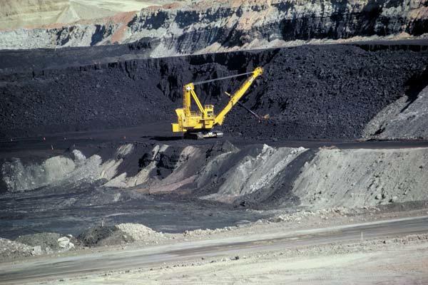 Image shows an excavator in front of a coal seam